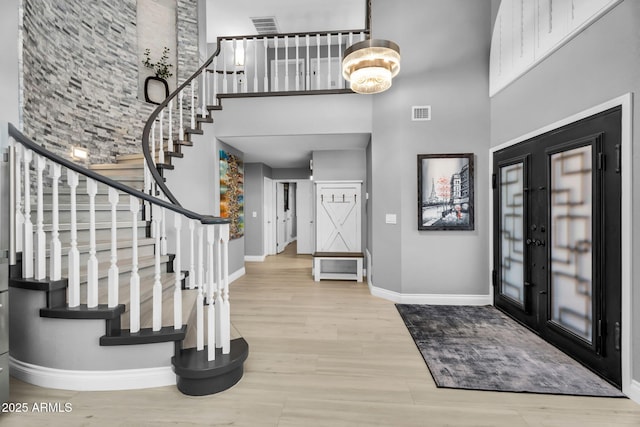 foyer entrance featuring stairway, wood finished floors, a high ceiling, and baseboards