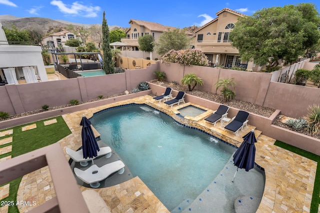 view of swimming pool featuring an outdoor living space, a fenced in pool, a fenced backyard, an in ground hot tub, and a patio