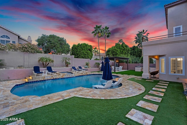 pool at dusk featuring a fenced in pool, an in ground hot tub, a fenced backyard, a pergola, and a patio area