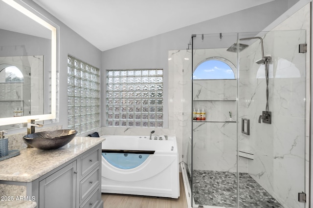 full bath featuring vanity, vaulted ceiling, a tub with jets, and a marble finish shower