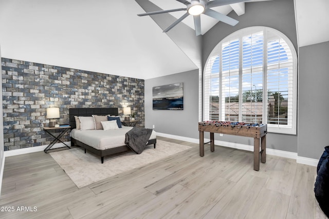 bedroom with baseboards, light wood-style floors, and an accent wall