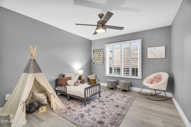 bedroom featuring ceiling fan, baseboards, and wood finished floors