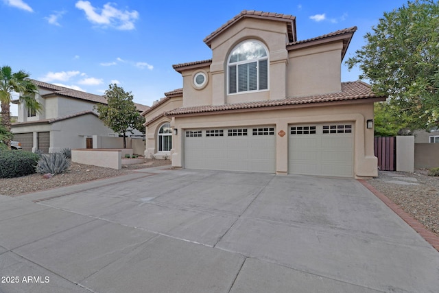 mediterranean / spanish home with concrete driveway, a tiled roof, an attached garage, and stucco siding