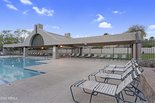 community pool with a patio and fence