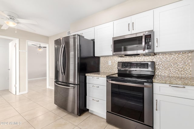 kitchen with decorative backsplash, white cabinetry, light tile patterned floors, and appliances with stainless steel finishes