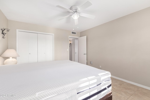 tiled bedroom with ceiling fan and a closet