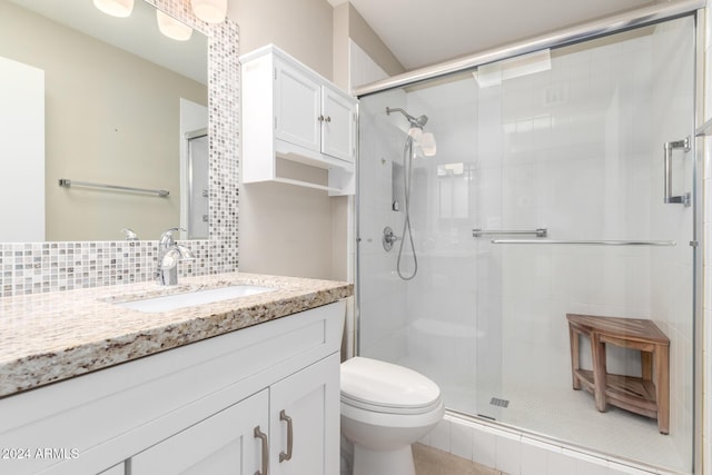 bathroom featuring vanity, tasteful backsplash, toilet, and walk in shower