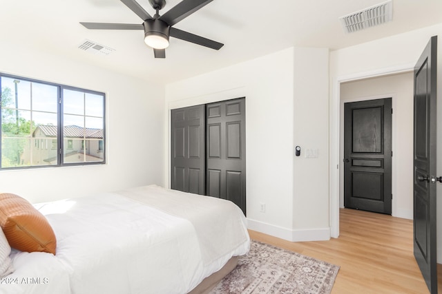 bedroom featuring light hardwood / wood-style flooring, a closet, and ceiling fan