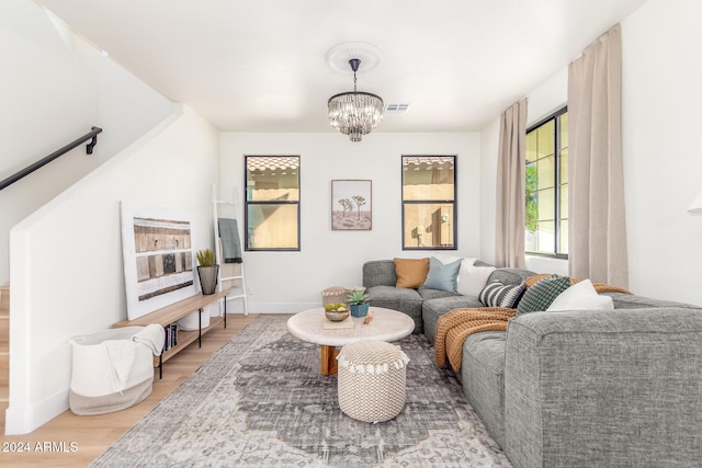 living room with hardwood / wood-style flooring and a notable chandelier