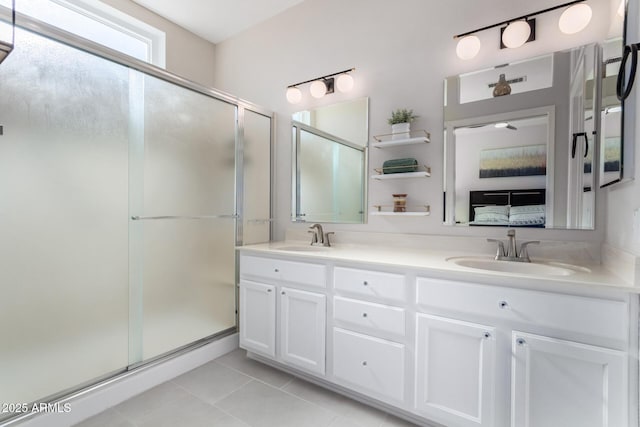 bathroom with tile patterned floors, a shower with door, and vanity