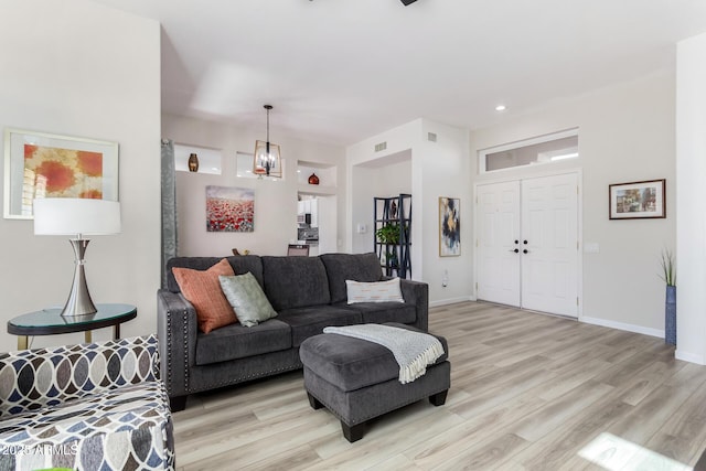 living room with a notable chandelier and light wood-type flooring