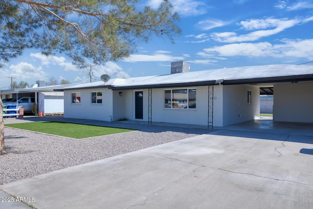 single story home with concrete driveway, an attached carport, and a front lawn