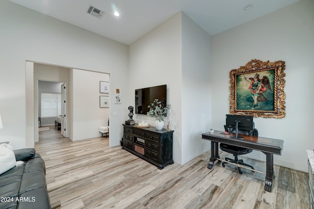 interior space with light wood-type flooring and vaulted ceiling