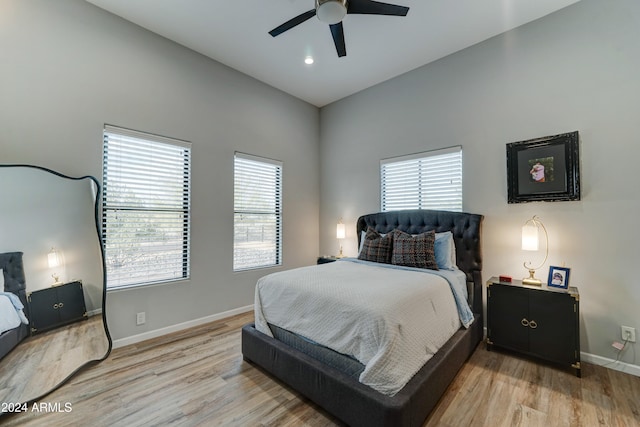 bedroom featuring light hardwood / wood-style floors, multiple windows, and ceiling fan