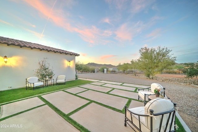 patio terrace at dusk featuring a mountain view