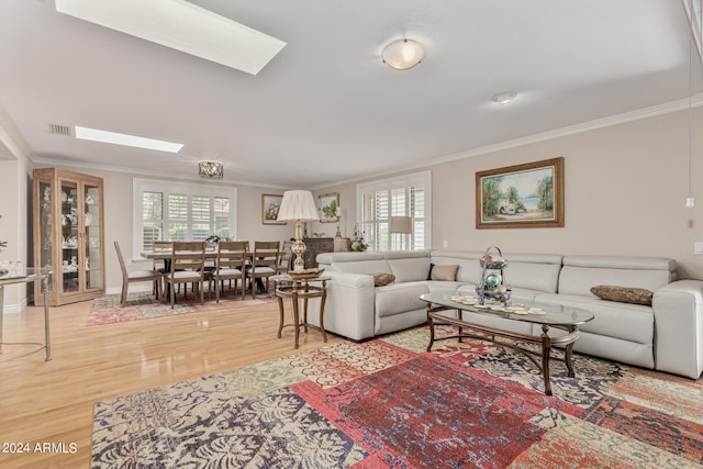 living room with hardwood / wood-style flooring, a skylight, and crown molding