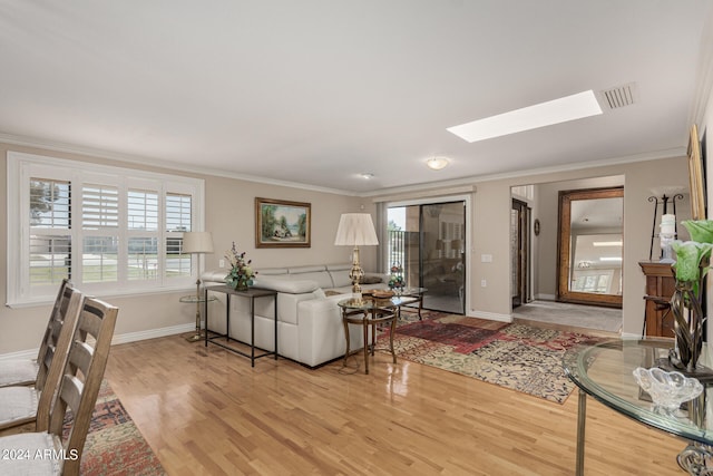 living room with a skylight, hardwood / wood-style floors, and crown molding