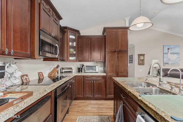 kitchen with sink, vaulted ceiling, light wood-type flooring, and stainless steel appliances