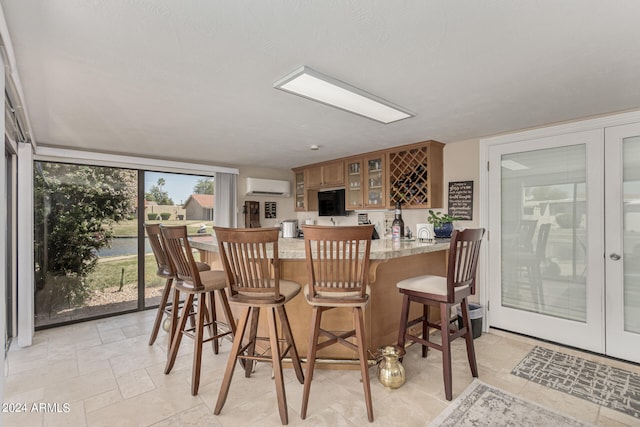 interior space featuring a wall mounted AC, light tile flooring, and light stone counters