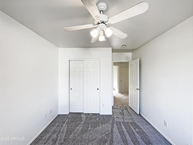 unfurnished bedroom featuring a closet, dark carpet, and ceiling fan