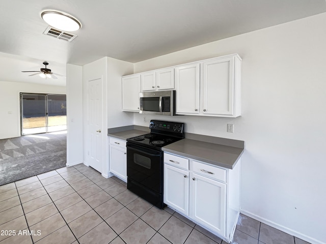 kitchen with electric range, ceiling fan, white cabinets, and light colored carpet