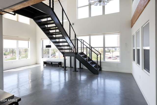 stairs with concrete floors and a high ceiling