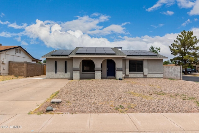 5702 S Beck Ave, Tempe, AZ 85283 - view of front facade featuring covered porch, fence, roof mounted solar panels, and stucco siding