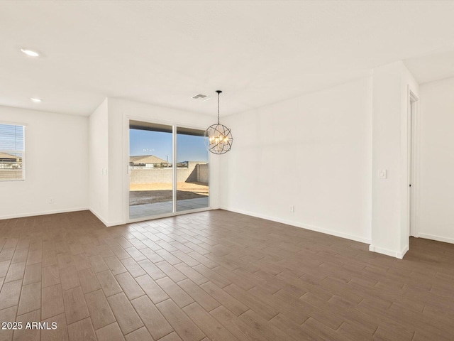 unfurnished room with an inviting chandelier