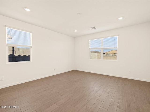 unfurnished room with hardwood / wood-style flooring and a wealth of natural light