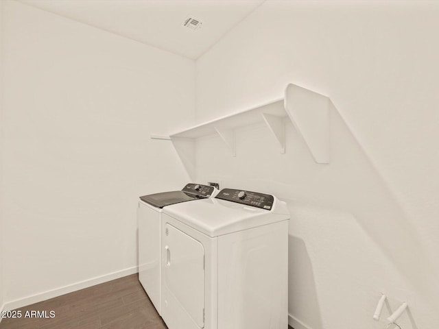 laundry room featuring washer and dryer and dark hardwood / wood-style flooring