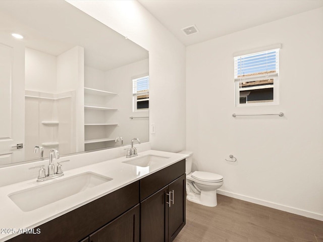 bathroom with toilet, vanity, and wood-type flooring