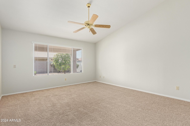 carpeted spare room with ceiling fan and vaulted ceiling