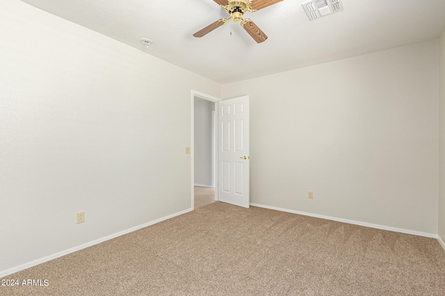 spare room featuring ceiling fan and carpet