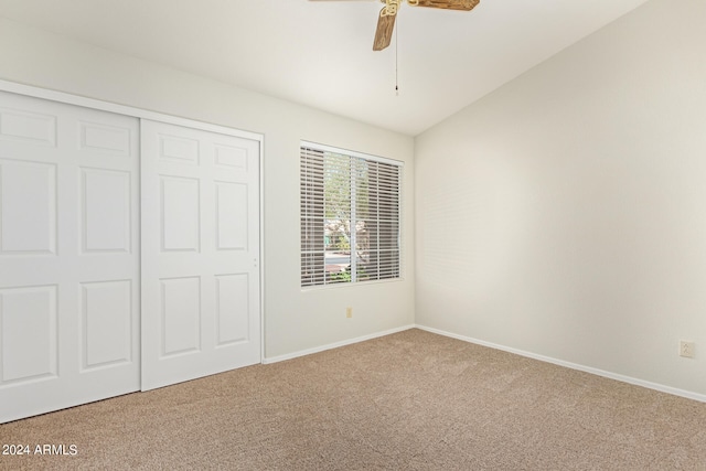 unfurnished bedroom featuring vaulted ceiling, carpet flooring, and ceiling fan