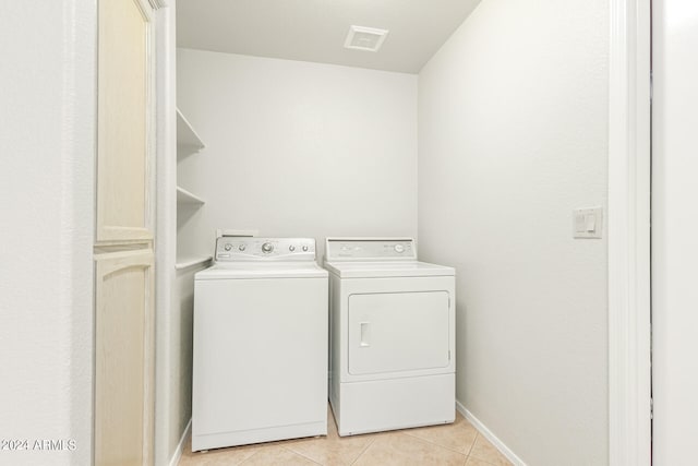 laundry area featuring washing machine and clothes dryer and light tile patterned floors