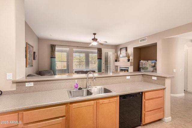 kitchen featuring black dishwasher, sink, light tile patterned floors, ceiling fan, and light brown cabinets