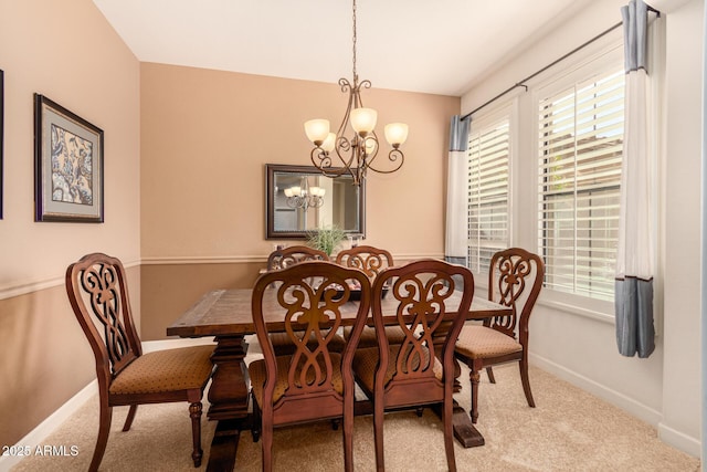 dining area featuring light carpet and an inviting chandelier