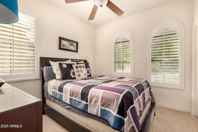 carpeted bedroom featuring multiple windows and ceiling fan