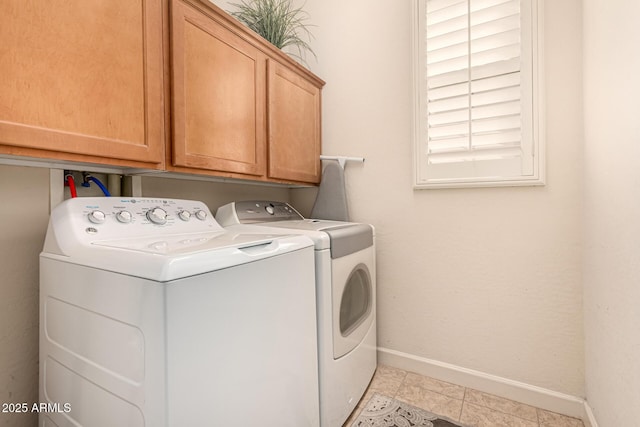 laundry room with independent washer and dryer, cabinets, and light tile patterned floors