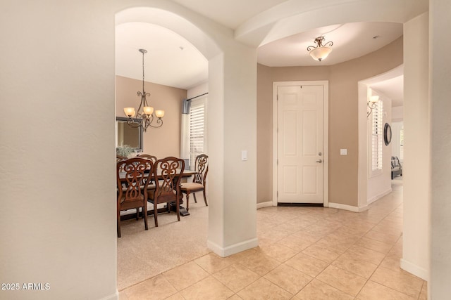 interior space featuring light colored carpet and a chandelier