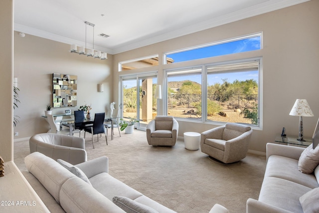 living room featuring carpet, ornamental molding, and a chandelier