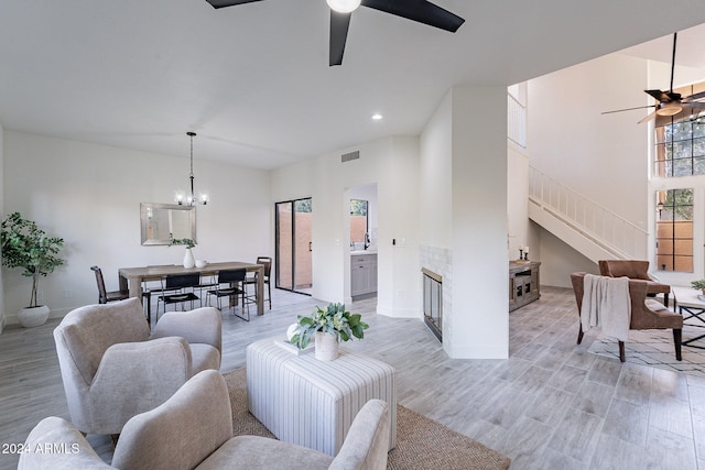 living room with light hardwood / wood-style flooring and ceiling fan with notable chandelier