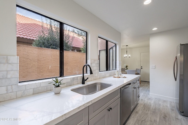 kitchen with gray cabinets, sink, stainless steel appliances, and plenty of natural light