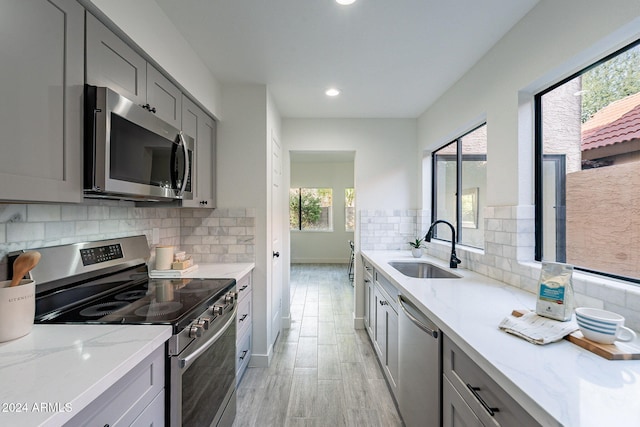 kitchen with gray cabinets, a healthy amount of sunlight, and stainless steel appliances