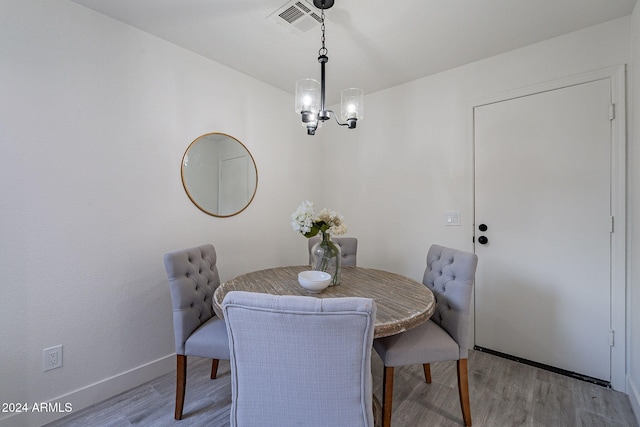 dining space with a chandelier and light wood-type flooring