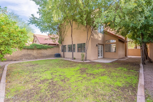 back of house with a lawn and central AC unit