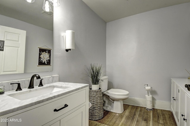 bathroom featuring vanity, hardwood / wood-style floors, and toilet