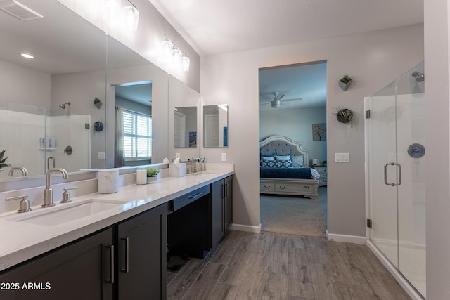 bathroom featuring ceiling fan, hardwood / wood-style floors, a shower with shower door, and vanity