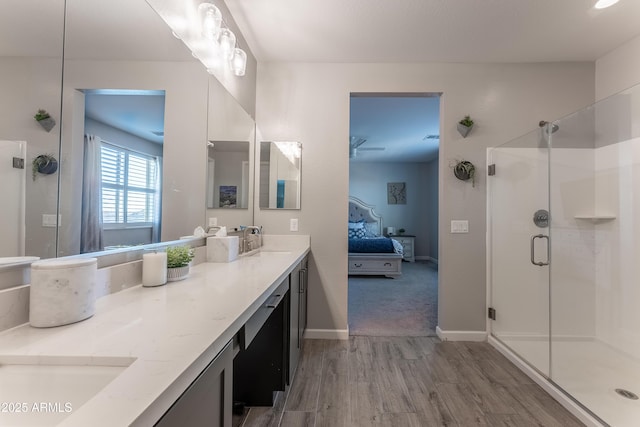 bathroom with hardwood / wood-style flooring, vanity, and an enclosed shower