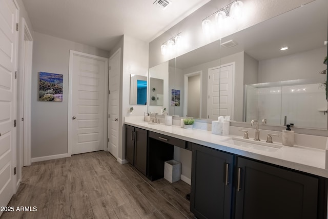 bathroom with a shower with shower door, wood-type flooring, and vanity